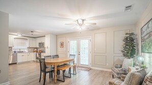 A spacious kitchen with a dining area, a ceiling fan, and a view of the outside.