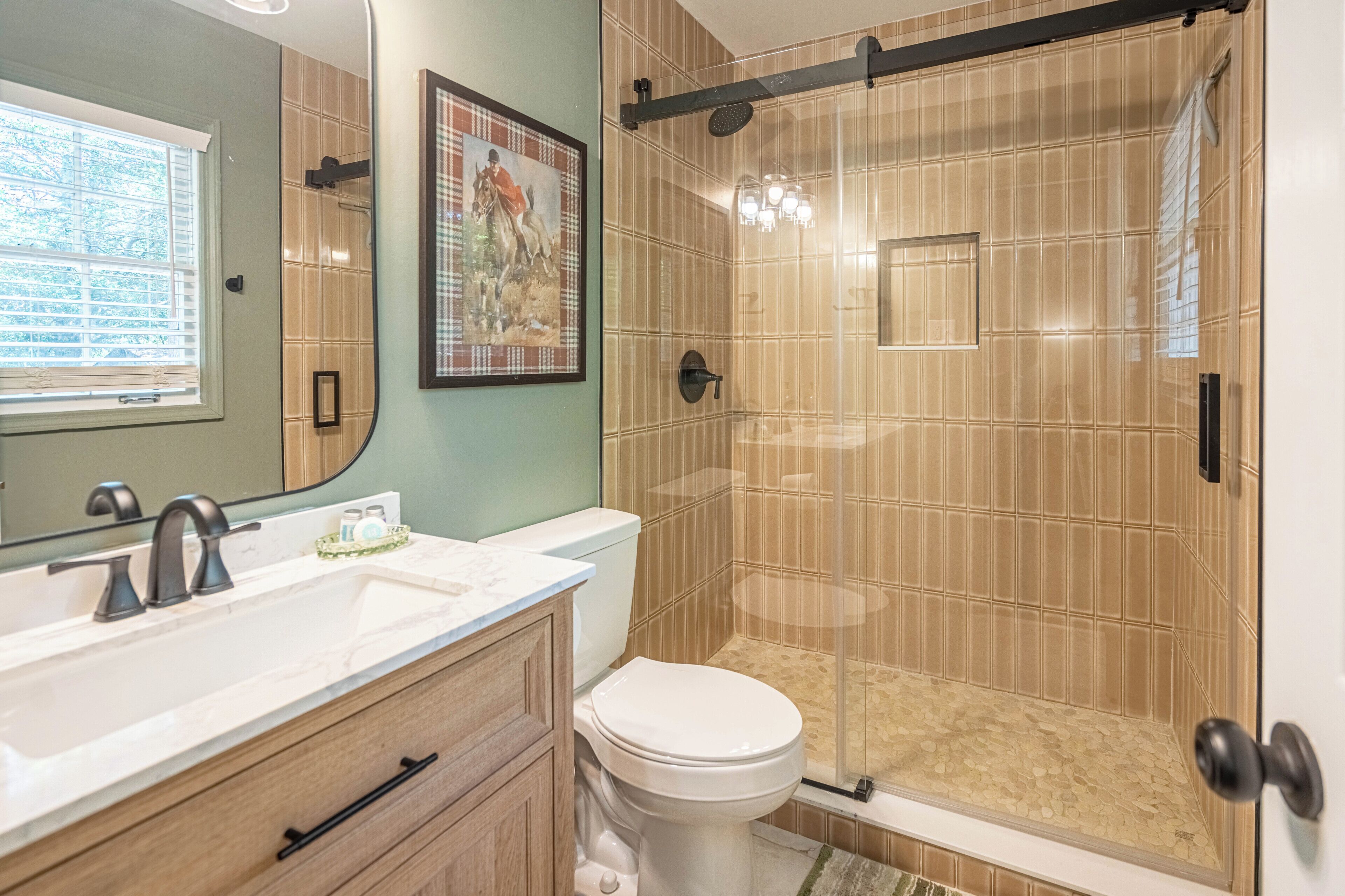 A bathroom with a shower, toilet, and sink.
