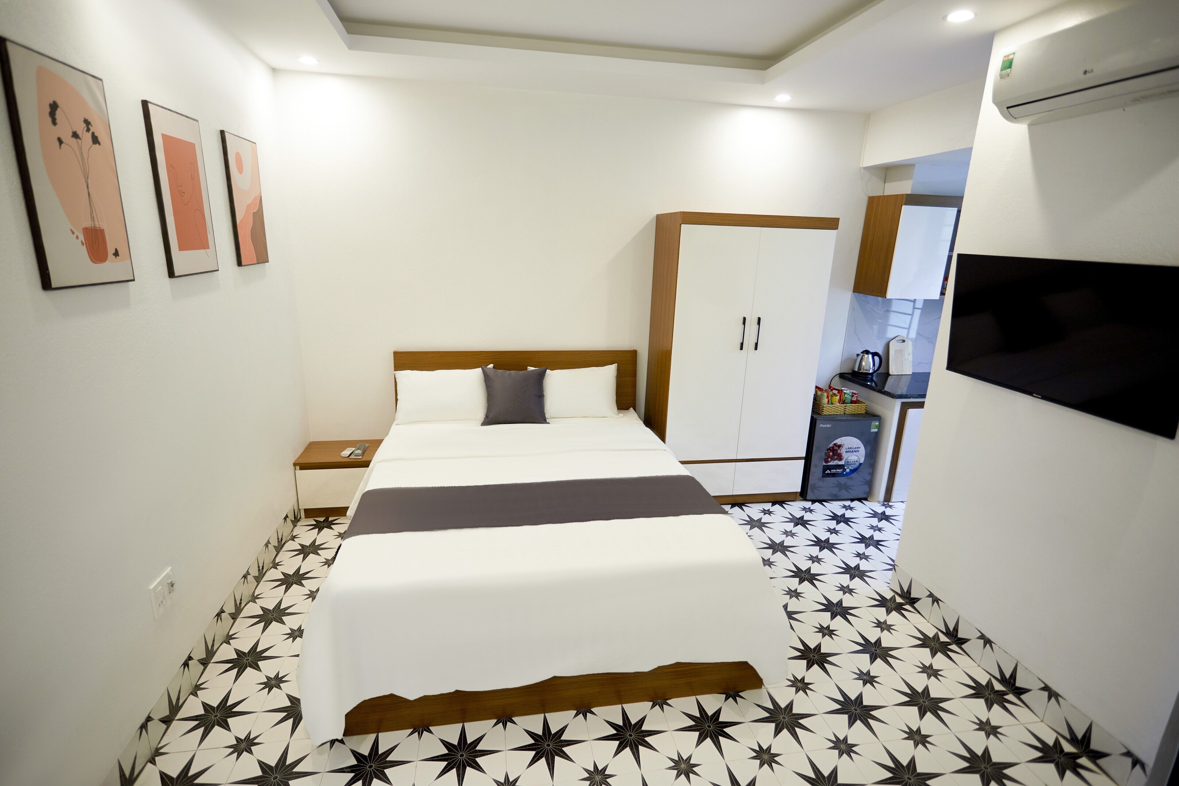 A hotel room with a bed, a wardrobe, a TV, and a coffee machine.