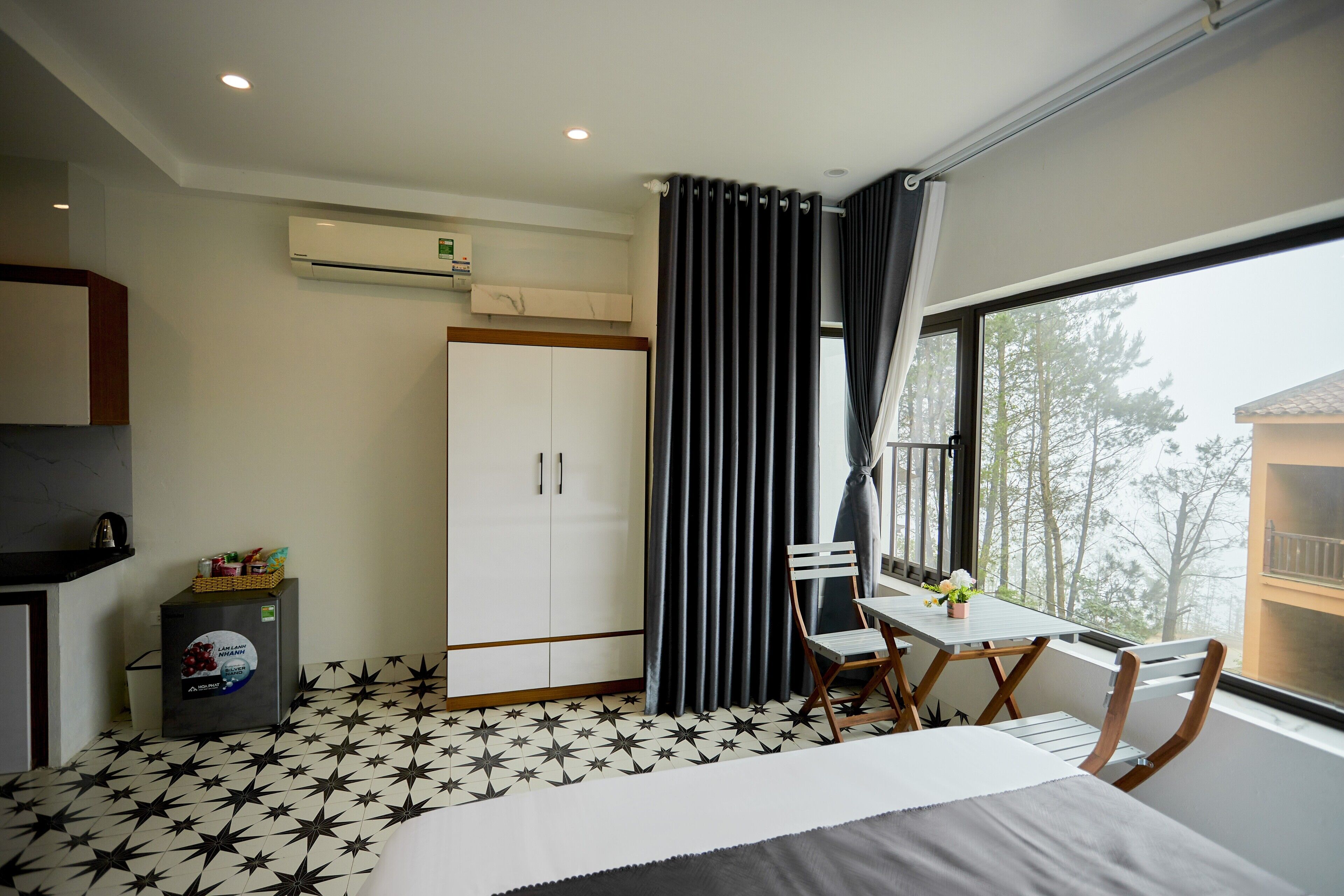 Quarto com cama, escrivaninha, cadeira, guarda-roupa e ar condicionado.
