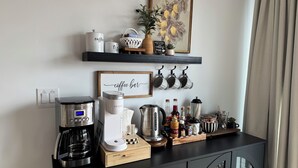 A coffee station with a Keurig machine, a coffee maker, and various coffee-related items on a black countertop. - Cozy Winter Escape, New Build with 3 Car Garage (Tooele)
