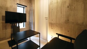 A room with a TV on a stand, a small table, and a chair. - AirHOMETOKYO EBISU 101 (Tokyo)