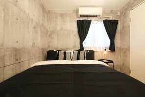 A bedroom with a bed, a window with curtains, an air conditioning unit, and a bedside table with a lamp. - AirHOMETOKYO EBISU 101 (Shibuya-ku)