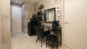 A compact office space with a desk, chair, and a computer. A clock and a thermostat are mounted on the wall. - AirHOMETOKYO EBISU 101 (Tokyo)