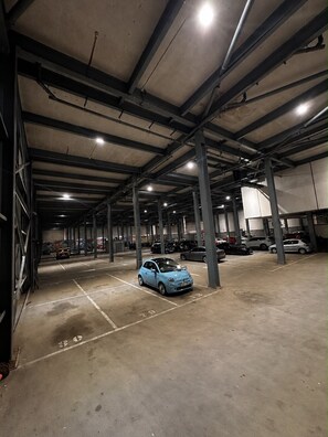 Eine mehrgeschossige Parkgarage mit Betonböden und Stahlträgern, mit mehreren parkenden Autos.