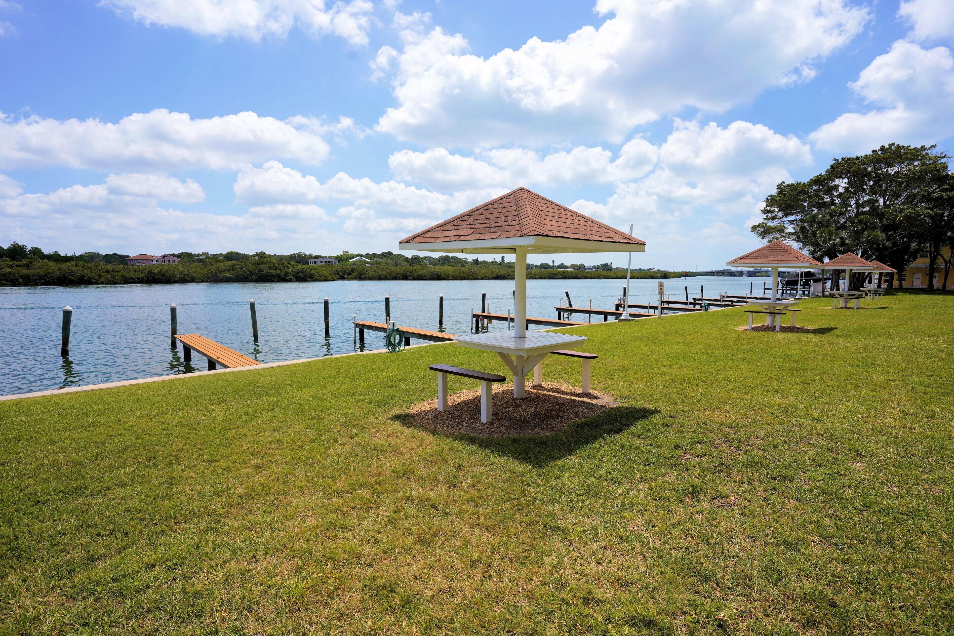A lakeside park with picnic tables and gazebos.