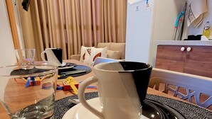 Een eethoek met een tafel gedekt voor twee personen, een glas water en een mok.