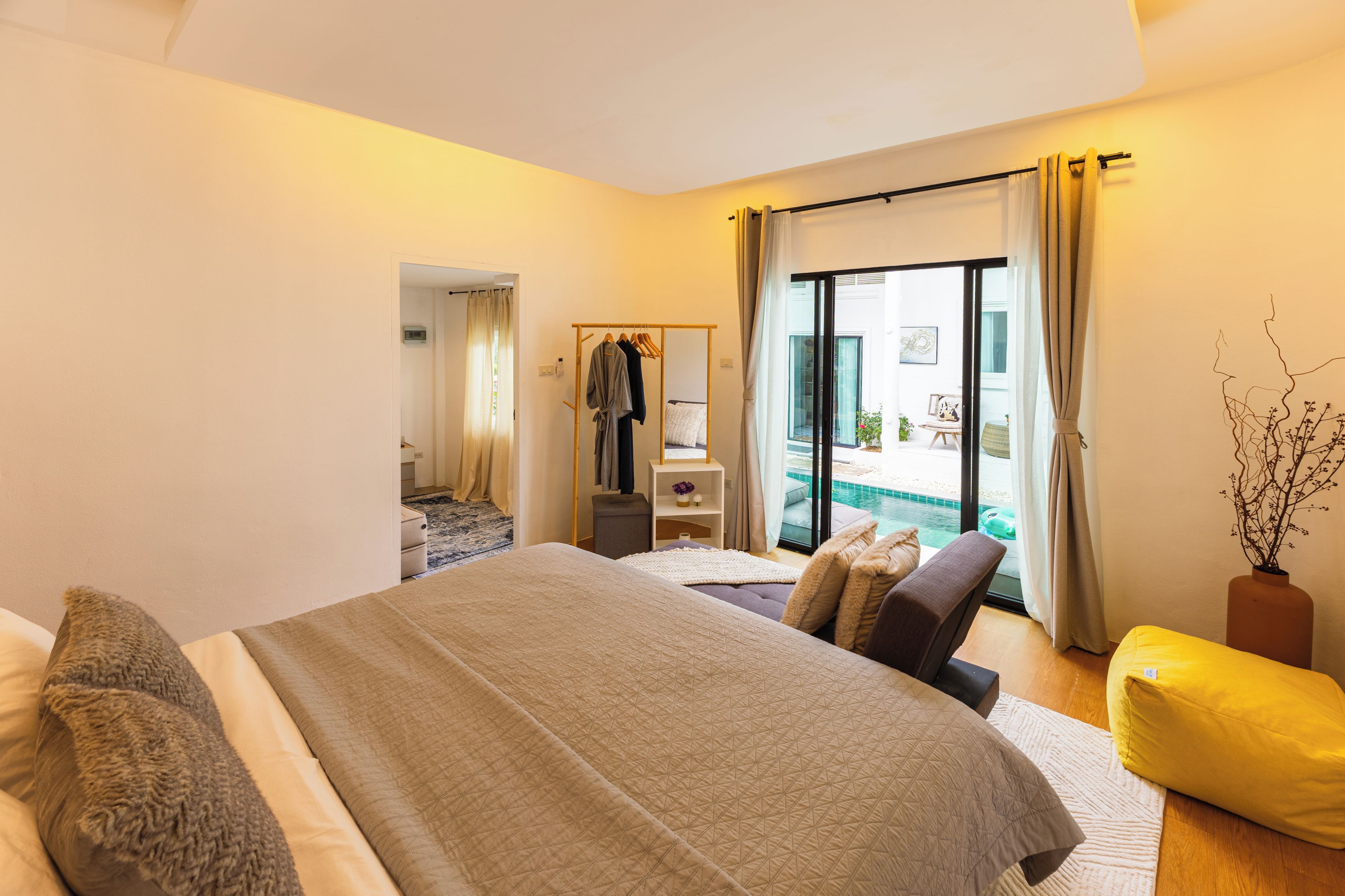 Une chambre d’hôtel comprenant un lit, un coin salon, une petite table et une vue sur la piscine.