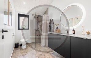 Ein modernes Badezimmer mit Dusche, Toilette und Waschtisch.
