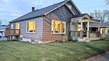 A two-story house with a covered porch and a fenced yard.