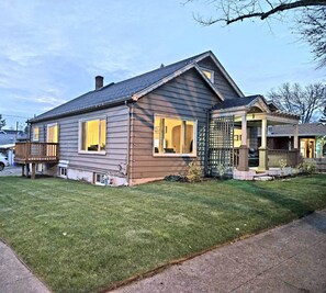 A two-story house with a covered porch and a fenced yard.