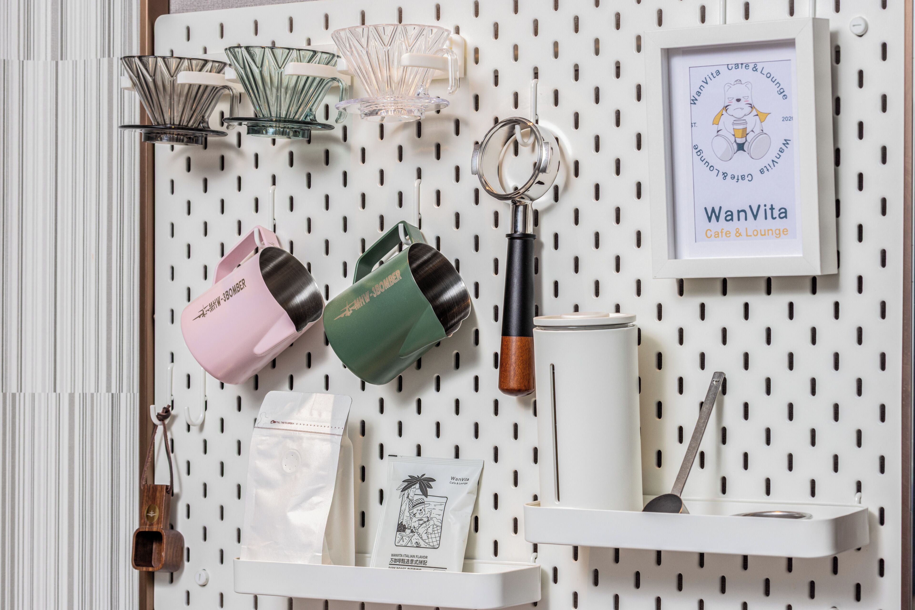 A pegboard wall with various kitchen items like a coffee maker, a kettle, and a framed certificate.
