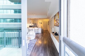 A modern apartment with a kitchen, dining area, and a balcony. - Buckhead Serenity Skyline Retreat (Atlanta)