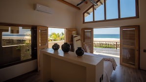 A room with a large window overlooking the beach, a ceiling fan, and a wooden ceiling. - Beach Hose with Private Pool. Casa Quinta Nayaa (El Tomatal)