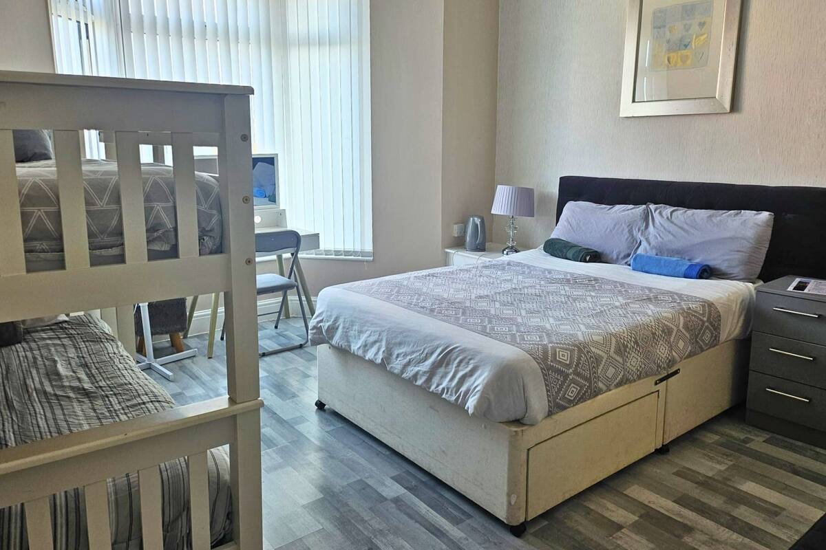Un dormitorio con cama, escritorio y silla.