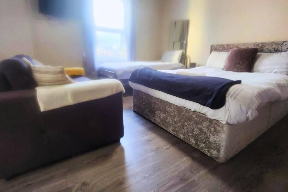 Una habitación de hotel con una cama grande, un sofá y una mesita.