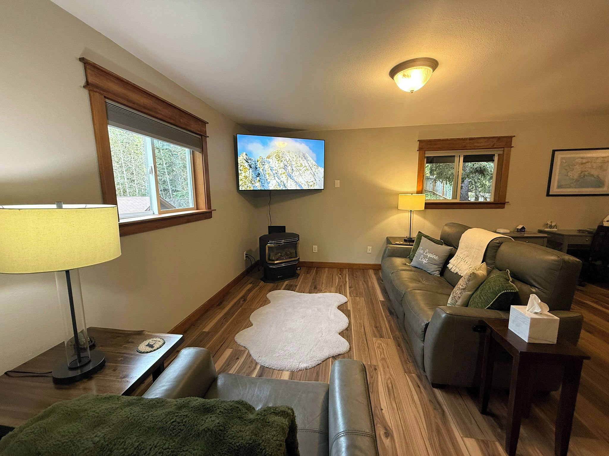 Una sala de estar acogedora con chimenea, televisor montado en la pared y un área de descanso confortable.