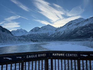Schneegebirgslanschaft mit einem Fluss und einem Schild mit der Aufschrift 'Eagle River Nature Center'.
