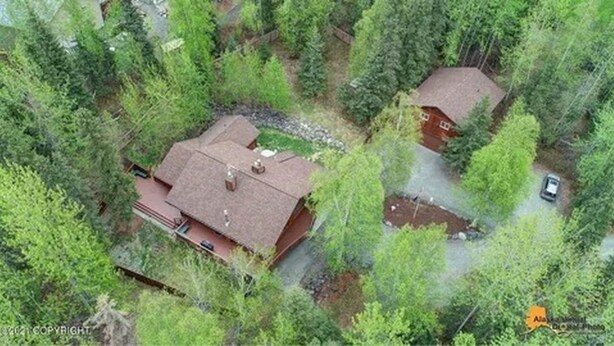 Eine Luftaufnahme einer Anlage mit zwei Gebäuden, umgeben von dichtem Wald.