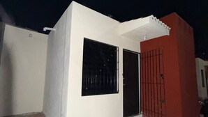 Il s’agit d’un petit bâtiment d’un seul étage, à l’extérieur blanc, avec un mur d’accent rouge. Il est doté d’une grande fenêtre et d’une porte avec un portail en métal.