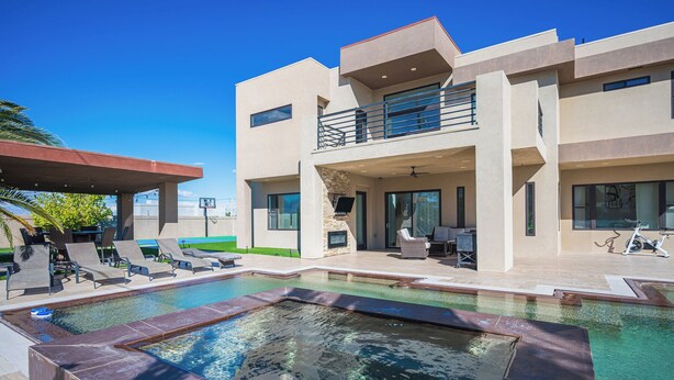 A modern house with a swimming pool, outdoor seating, and a covered patio area. - Phenomenal 6-bedroom villa with infinity pool in vibrant Las Vegas (Las Vegas)