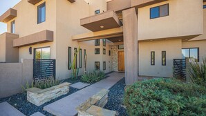 A modern building with a flat roof, multiple windows, and a stone pathway leading to the entrance. - Phenomenal 6-bedroom villa with infinity pool in vibrant Las Vegas (Las Vegas)