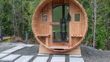 A wooden cabin with a circular door, a small window, and a doorbell.