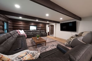 A modern living room with a sectional sofa, a coffee table, and a massage chair.