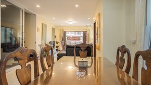 A dining area with a wooden table, chairs, and a glass ashtray. - First Private Pool Villa, 4-bedroom private pool villa in peaceful Ao Nang, (Ao Nang)
