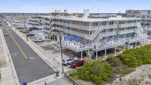 A multi-story hotel with outdoor seating and a parking lot.