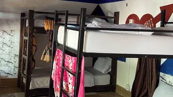 Un dormitorio con literas, suelo de cuadros y techo pintado.