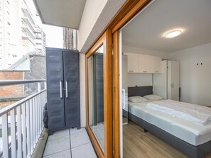 Une chambre moderne avec un lit, une armoire et un balcon.