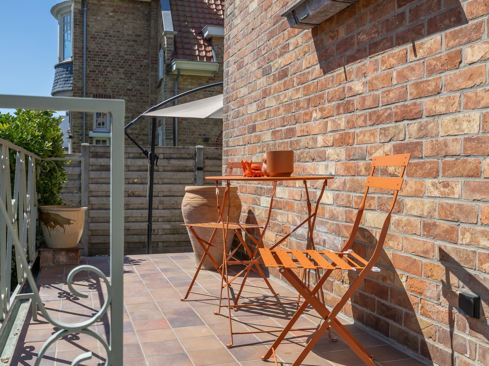 Eine Terrasse im Freien mit einer Ziegelwand, einem Tisch und Stühlen.