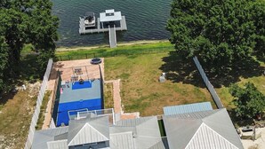 Ein Wohnhaus mit Schwimmbad, Bootsanleger und Boot.