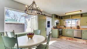A kitchen with a round dining table, chairs, a chandelier, and a view of the outside. - Group-Friendly Oasis Near Roper Lake State Park! (Safford)