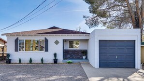A single-story house with a garage, a stone accent wall, and a gravel driveway. - Group-Friendly Oasis Near Roper Lake State Park! (Safford)