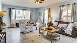 A spacious living room with a brown leather sofa, patterned armchairs, and a wooden coffee table. - Group-Friendly Oasis Near Roper Lake State Park! (Safford)