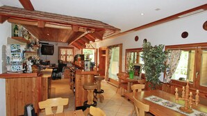 A wooden interior with a bar area, dining table, chairs, and a large potted plant. - Holiday Home in Nysted by Baltic Sea (Saas-Balen)