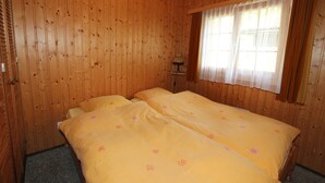 A room with wooden walls and a bed with yellow bedding. - Holiday Home in Nysted by Baltic Sea (Saas-Balen)