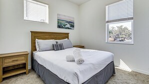 Una camera da letto con un letto grande, due comodini, un quadro al muro e una finestra con persiane.