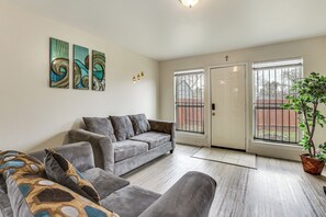 Ein modernes Wohnzimmer mit einem grauen Sofa, einem Couchtisch und einer Zimmerpflanze.