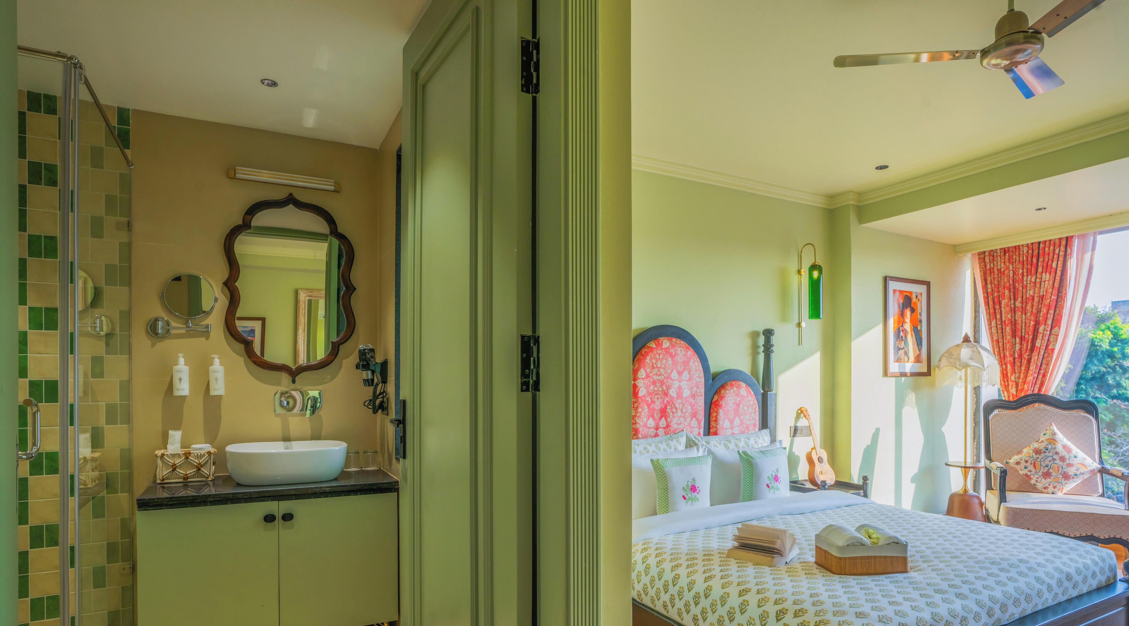 Una habitación con baño, una cama, una guitarra y un ventanal con cortinas.