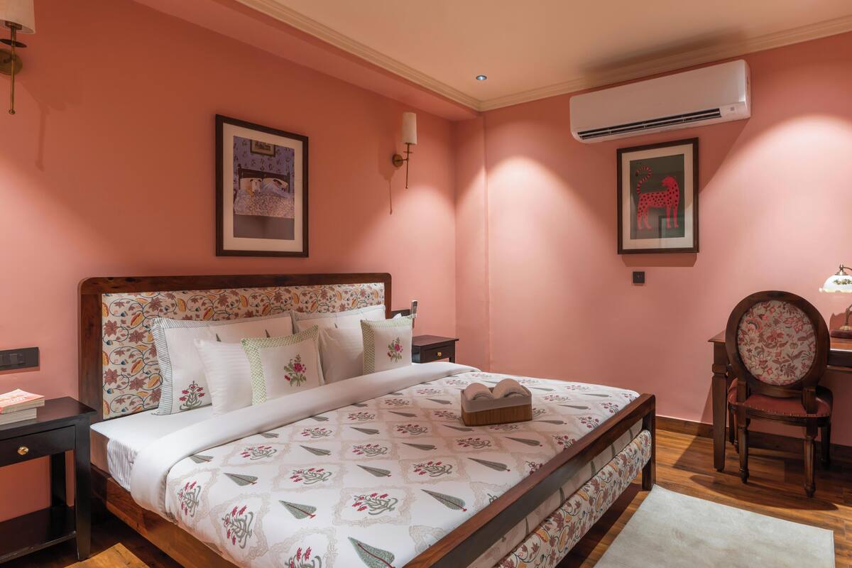 Un dormitorio con una cama de madera, una mesita de noche, una silla y un equipo de aire acondicionado.