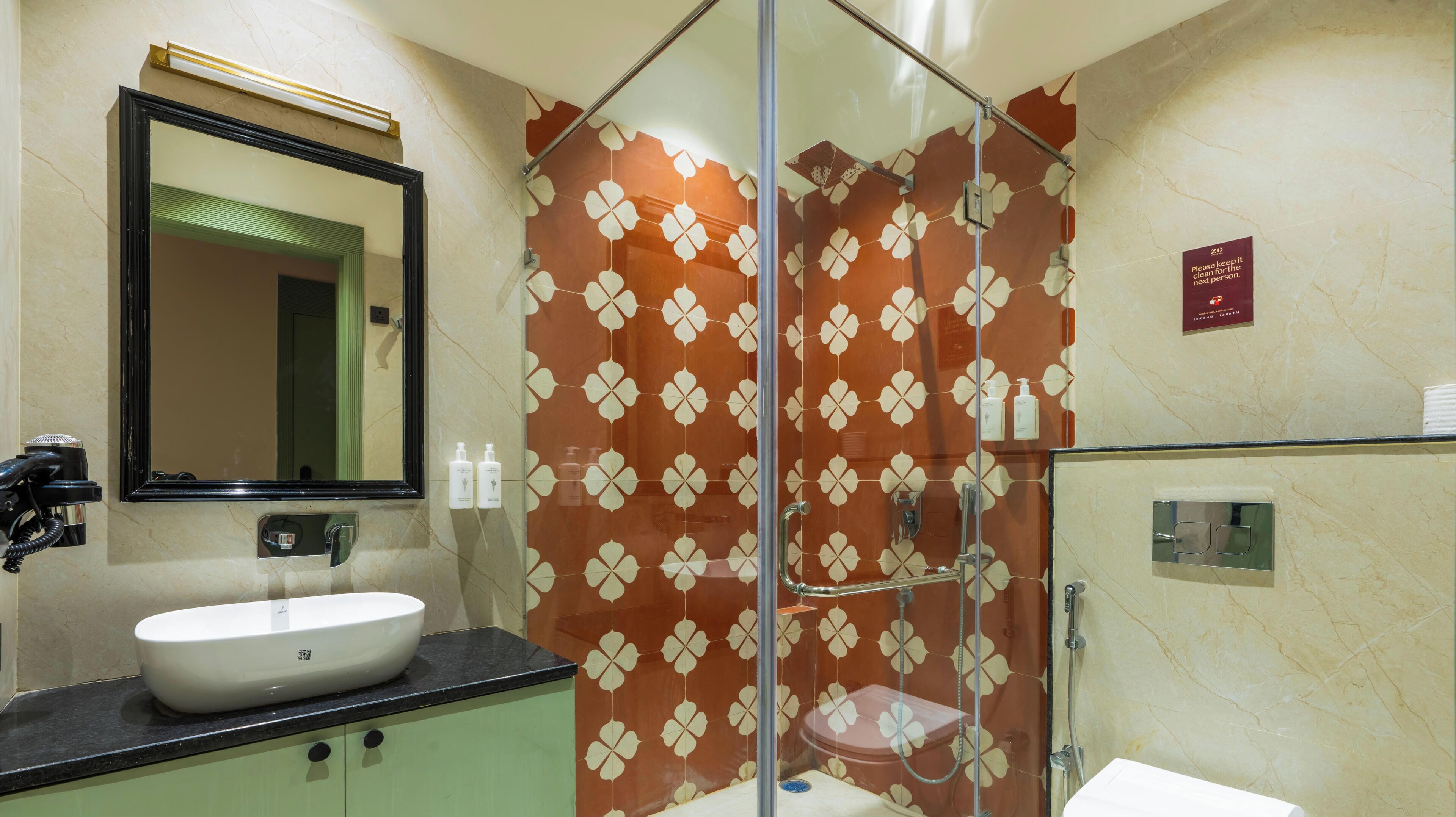 A bathroom with a sink, mirror, and glass shower enclosure.