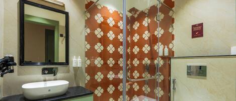 A bathroom with a sink, mirror, and glass shower enclosure.
