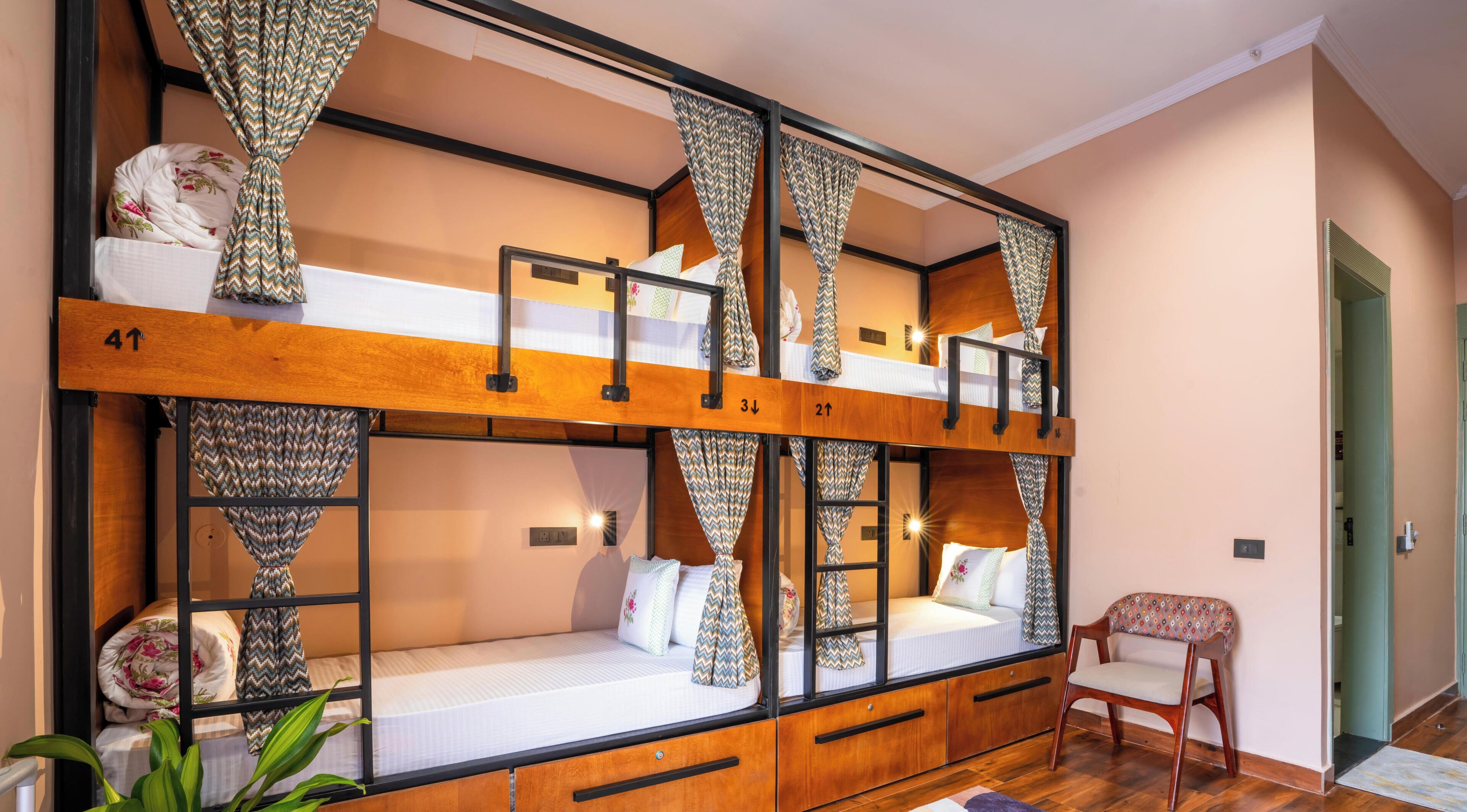 A bunk bed room with a wooden frame, numbered bunks, and patterned curtains.