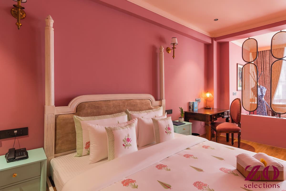 Un dormitorio con una cama grande, un escritorio, una silla y una ventana con vistas.
