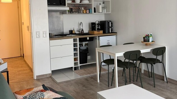 Um espaço compacto com cozinha americana, área de refeições e sofá.