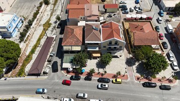 Vista aérea de un área residencial con varios edificios, una calle principal y coches estacionados.