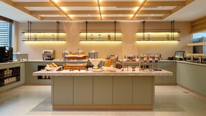 A modern kitchen with a central island, built-in shelves, and a coffee station. - Leston Hotel Sukhumvit (Bangkok)